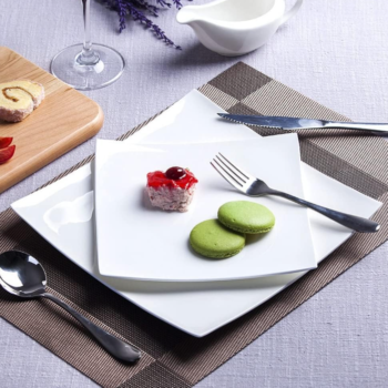White ceramic tableware set; includes plates, placemats, and napkin rings; ideal for family dining décor